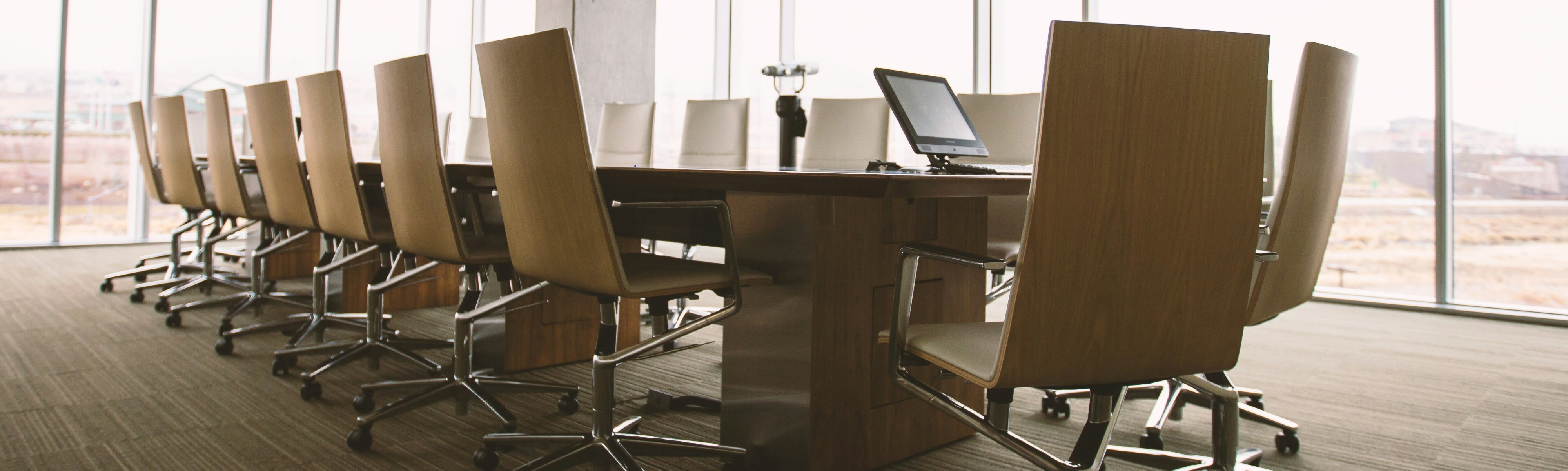 wood meeting table with wood chairs around it
