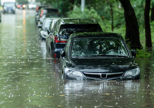 vertical line of cars on flooded street with water almost covering tire level