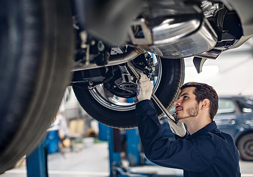 mechanic working on underneath of car