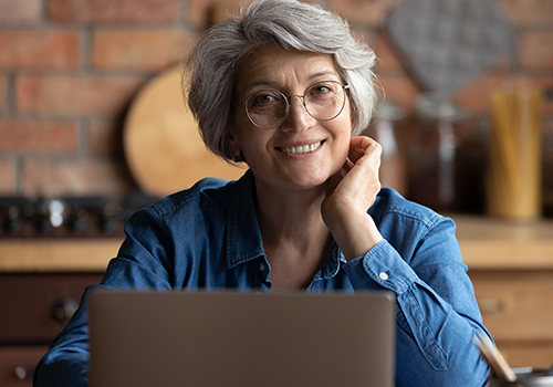 senior smiling in front of computer