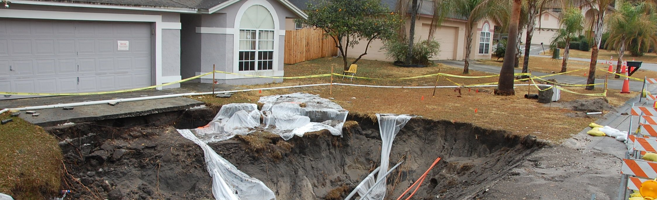House with large sinkhole in front yard