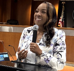 ICA Tasha Carter smiling and speaking at a podium