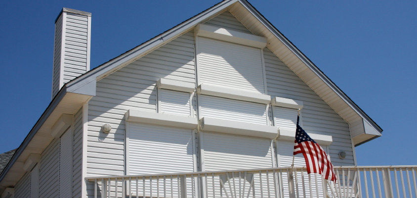 Hurricane shutters of various sizes installed on windows of a home