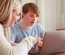 White mom developmentally disabled child at computer